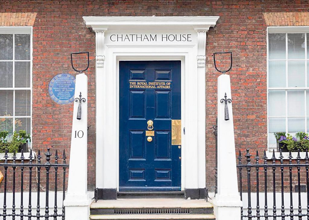 Eingang des Chatham House in London mit blauer Tür und dem Schriftzug „The Royal Institute of International Affairs“ über dem Türrahmen.
