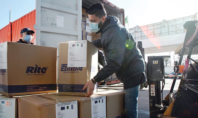 Amex verschifft Hilfsgüter in alle Welt. Am Bild sind zwei Männer die Kartons heben.